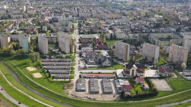 Widok z drona na osiedle w Nowym Sączu ukazujący zabudowę mieszkaniową i kościół św. Józefa